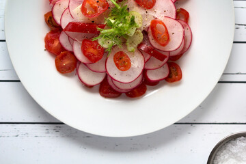 Close-up of radish and tomato salad served on table