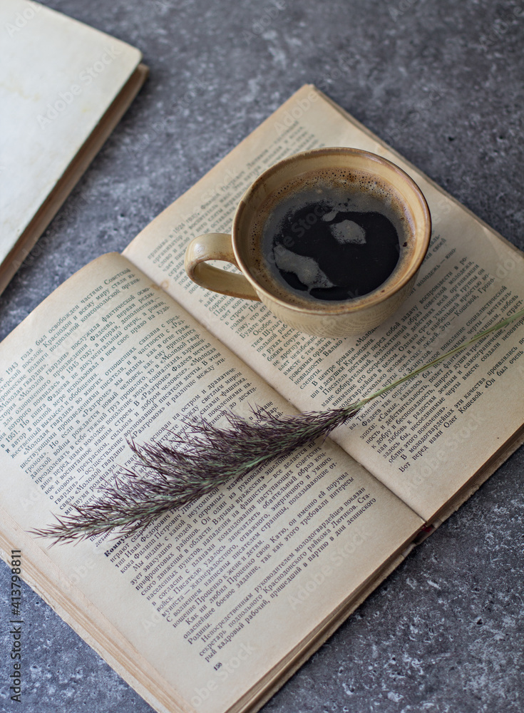 Wall mural a cup of black coffee sits on an open book