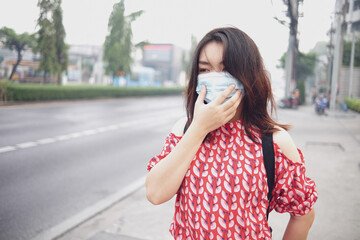 Woman asia wearing face mask protect filter against air pollution (PM2.5) or wear N95 mask. protect pollution, anti smog and Covid 19 viruses, Air pollution health problem.