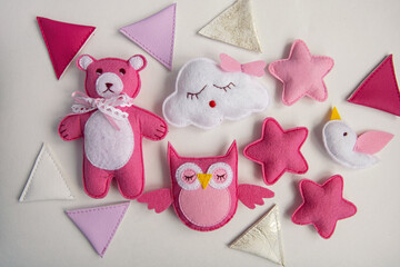 knitted toys cloud, star, bear, ram, owl, bird pink and blue colors lie on a purple background