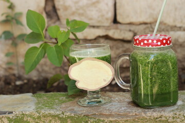 green diet drink in glass jar and in glasses with red lid for healthy life , selective focus. Copy space for your text 
