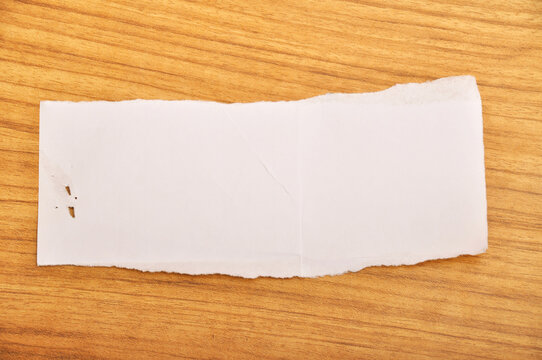 Grunge white crumpled paper texture, torn edge paper, on wooden floor