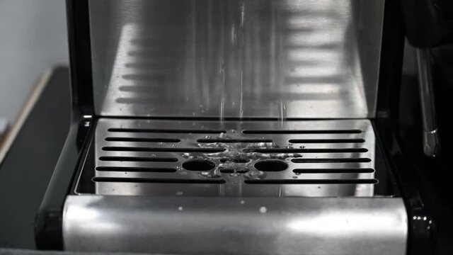 Professional barist Wash the coffee machine portafilter to prepare fresh morning espresso.
