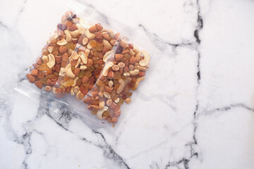 close up of many mixed nuts in a packet on table 