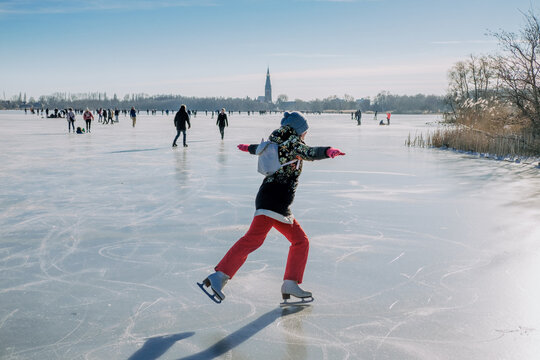 Woman skating on frozen winter lake in the Netherlands