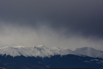 Fototapeta na wymiar Snowy mountains peaks with dark sky