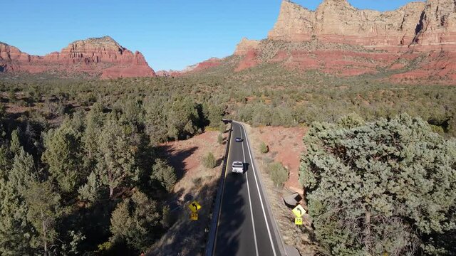 Stunning aerial Arizona landscape with red rocks and highway with two cars drive