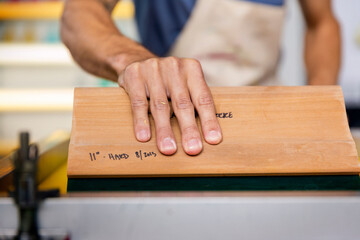 Close-up of hand pulling squeegee while working in workshop
