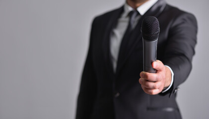 Man in a suit gives a microphone to speak
