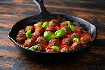 Vegetarian spaghetti with meat free, vegan meatballs in rich tomato sauce in iron cast pan