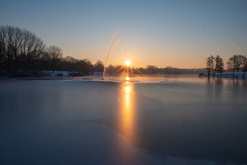 Fototapeta na wymiar Sonnenaufgang über zugefrorenem See