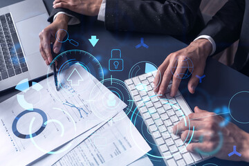 Two research and development specialists man and woman working on project to create a new approach to develop software to improve business. Technological icons over the table with document.