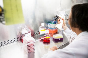 High angle view of senior female scientist using pipette during experiment in laboratory