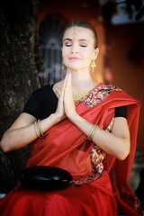 Obraz na płótnie Canvas A girl prays in an Indian temple at dawn