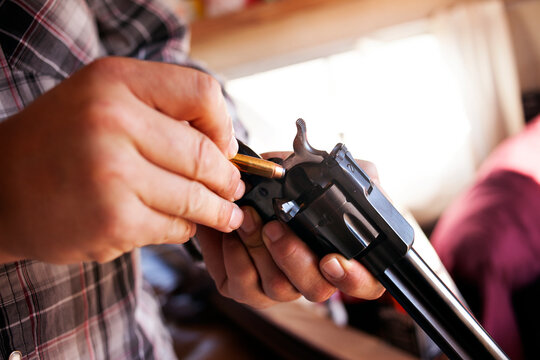 Close-up of man's hands loading revolver