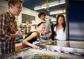 Friends playing at pinball machine in arcade