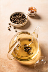 Organic green oolong tea in a glass teapot on light background, top view