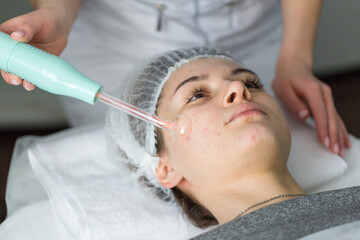 Obraz na płótnie Canvas Violet ray treatment on face at the beautician.