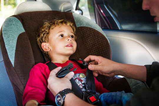 Cropped image of father fastening safety belt of son