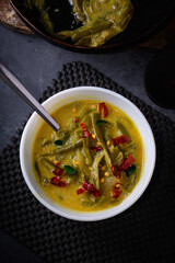 green beans curry dish, red chilies and curry leaves sprinkled on top, sri lankan food