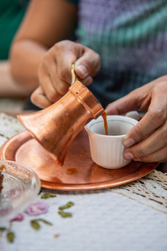woman pouring Bosnian coffee into small cup