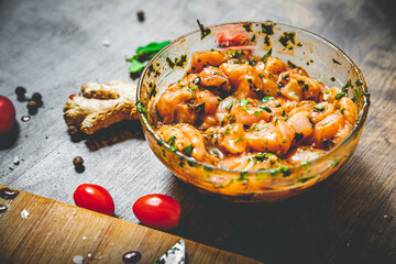 Raw marinated chicken meat with garlic, ginger and teriyaki sauce in a glass bowl on wooden table