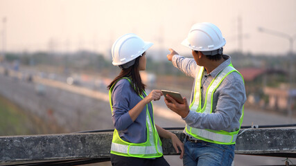 Two civil Engineering working with tablet on bridge highway