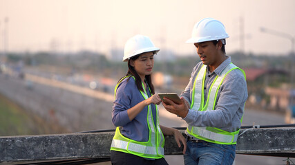 Two civil Engineering working with tablet on bridge highway