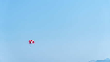 Colored parasail wing pulled by a boat in the sea water, Parasailing also known as parascending or parakiting.