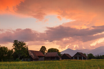 Clearing storm over a rural landscape with a traditional barn.