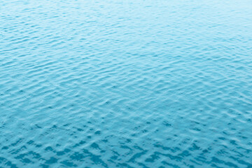 Water surface of swimming pool with sun reflection