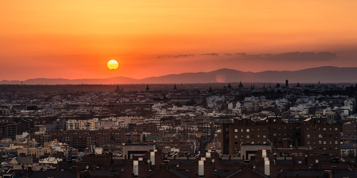 Partial sun eclipse over Madrid skyline on a warm summer sunset