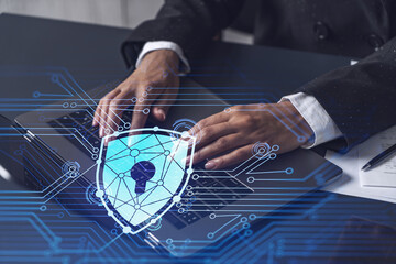 A woman programmer is typing a code on computer to protect a cyber security from hacker attacks and save clients confidential data. Padlock Hologram icons over the typing hands. Formal wear.