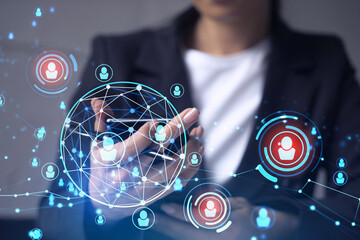 HR woman specialist in formal wear browsing social networks in the Internet in smart phone to find the best candidates to hire international team. Concept of success. Media hologram icons.