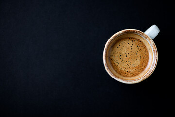 Cup of coffee on dark background. Top view. Copy space