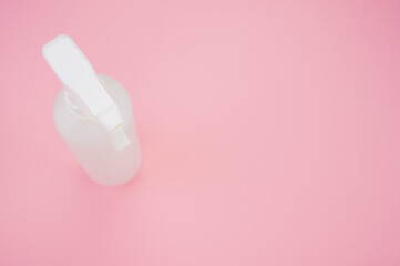 Closeup shot of a white plastic spray bottle isolated on pink background