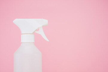 Closeup shot of a white plastic spray bottle isolated on pink background