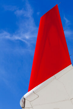 Airliner wing tip against a deep blue sky
