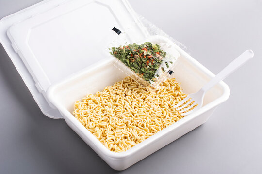 Instant Chinese noodles with spices on grey background. Asian Fast food, junk food, unhealthy food. Rolton. Doshirak.