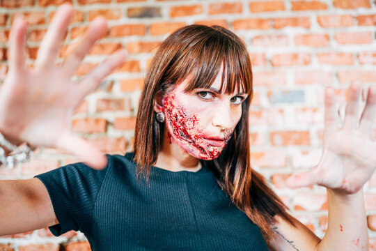 Woman with her face painted with terror wounds.