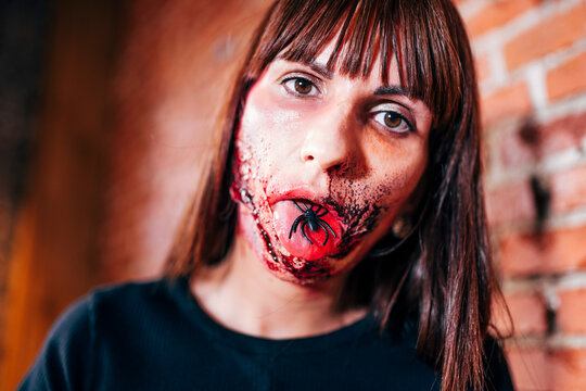 Woman with her face painted with terror wounds.