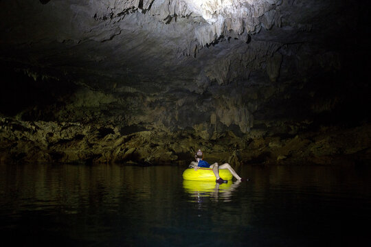 Man river tubbing in a cave