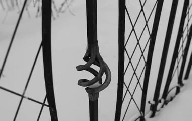 the railing of the bridge with forged elements on a winter landscape