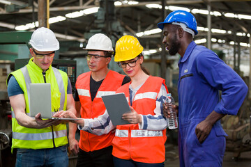 Diversity factory worker working with computer laptop in factory. Male and female worker wearing safety uniform, helmet and gloves at work factory. Group of worker working at factory