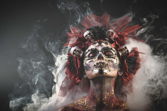 Santa Muerte Young Girl with Artistic Halloween Makeup and with Sculls