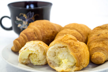 Тарелка с вкусными круассанами на светлом фоне, крупным планом.