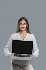 Joyful woman with glasses holding open laptop