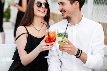 couple seating on the beach bar and drink cocktails. couple drink cocktails