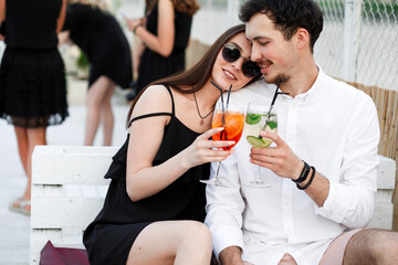 couple seating on the beach bar and drink cocktails. couple drink cocktails