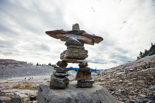 Inukshuk standing tall in a mountain setting.